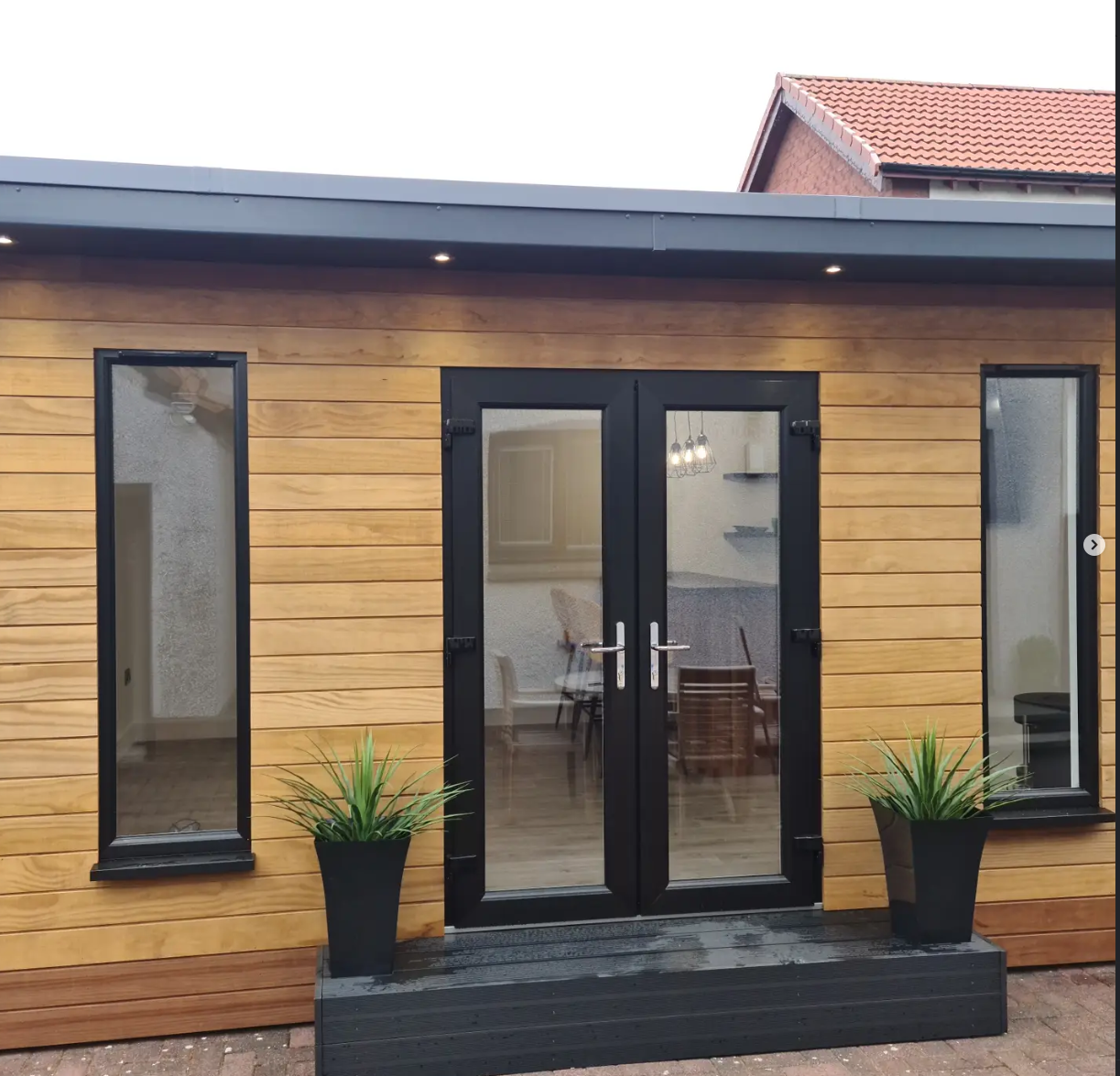 Exterior lighting installed on a timber-clad garden room